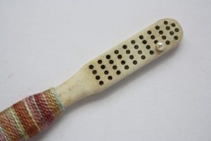 Old toothbrush bound in coloured silk