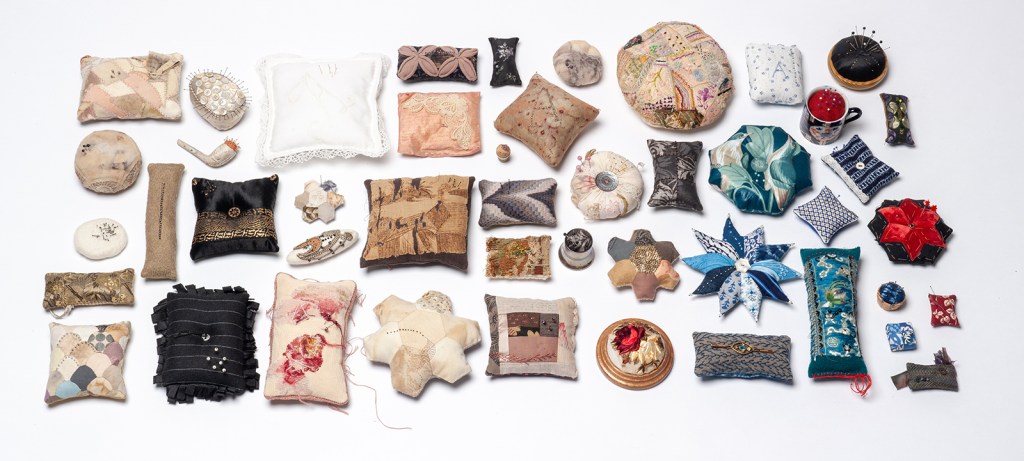 image of 46 decorative pincushions arranged for exhibition